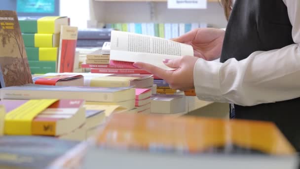 Vrouw op zoek naar een boek — Stockvideo