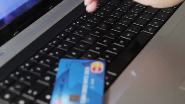Жінка тримає кредитну картку на ноутбуці для інтернет-магазинів — стокове відео