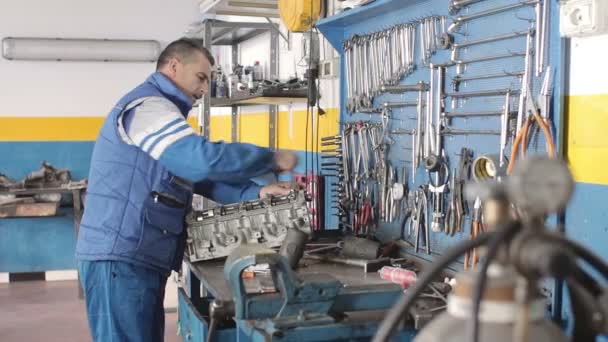 Auto mechanic repairing a part of a car engine — Stock Video