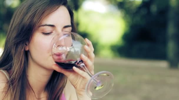Задумчивая женщина пьет красное вино — стоковое видео