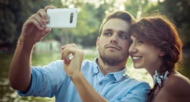 aşık genç çift yapar selfie genel bir parkta: akıllı telefon, fotoğraf
