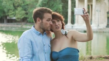 Genç çift küçük göl kamu Parkı fotoğraf çekmek: 4 k görüntüleri