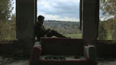 terk edilmiş bir binada eşiğinde yalnız asker Sigara