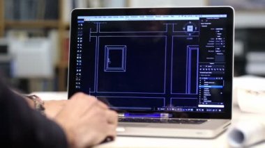 bir dizüstü bilgisayarda bir cad yazılımı ile iş yerinde erkek mimar: takım çalışması