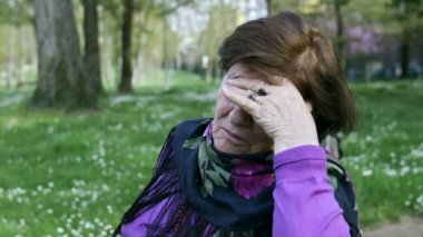 Çaresiz yaşlı kadın parkta tek başına oturmak: üzgün yaşlı kadın