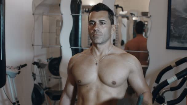 Взрослый мужчина использует вес упражнения в домашнем тренажерном зале, чтобы оставаться в форме и stren — стоковое видео