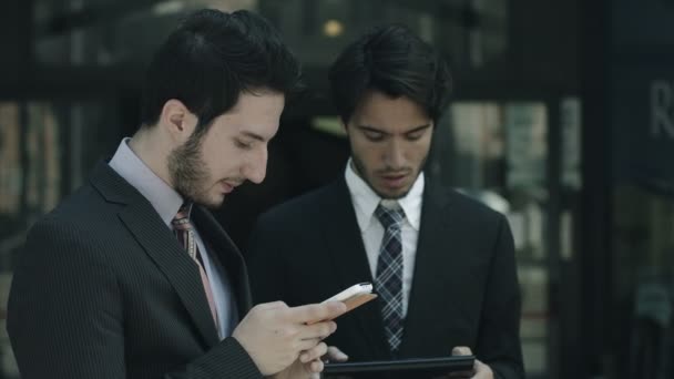 Uomini d'affari che utilizzano smartphone e tablet vicino all'ufficio: lavoro di squadra — Video Stock