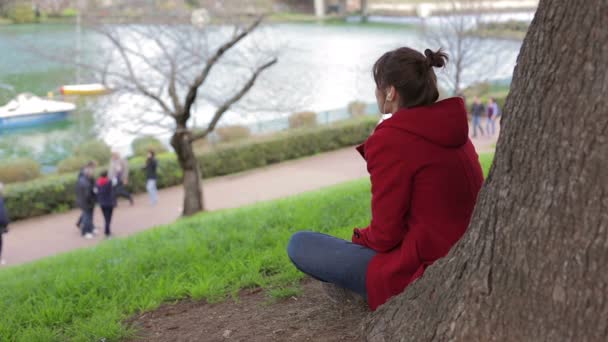 Ragazza pensierosa sotto l'albero: donna, pensieri, erba, seduta, pensiero, problemi — Video Stock