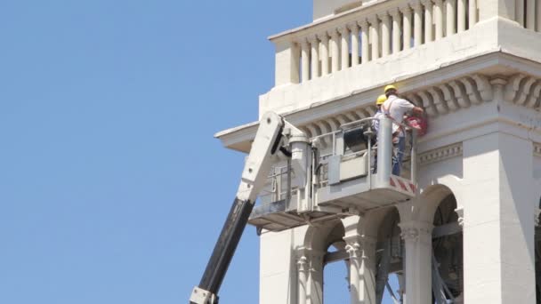 Kőműves munkát karbantartás a templom egy boom lift - daru - munkavállaló — Stock videók