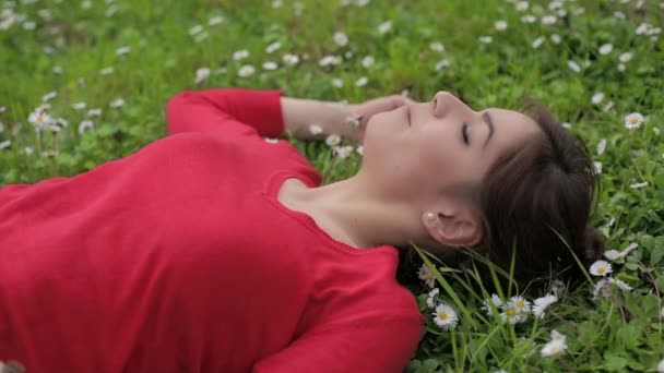 Красивая молодая женщина, отдыхающая весной на природе: парк, трава, лежачая — стоковое видео