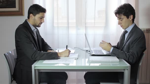 Ofiste masasında dijital tablet ve dizüstü kullanarak iki iş adamları — Stok video