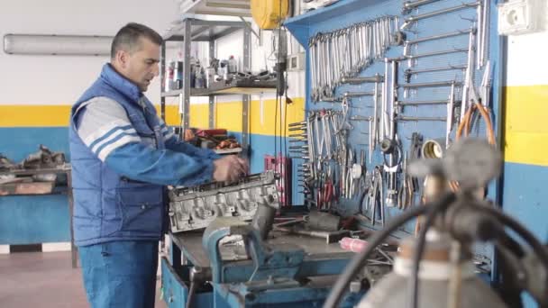 Mecánico de automóviles reparando una parte de un motor de coche — Vídeos de Stock