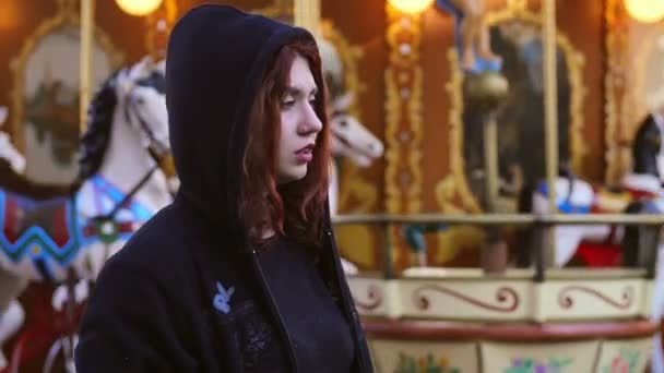 Jonge vrouw in een hoodie depressief in een kermis — Stockvideo