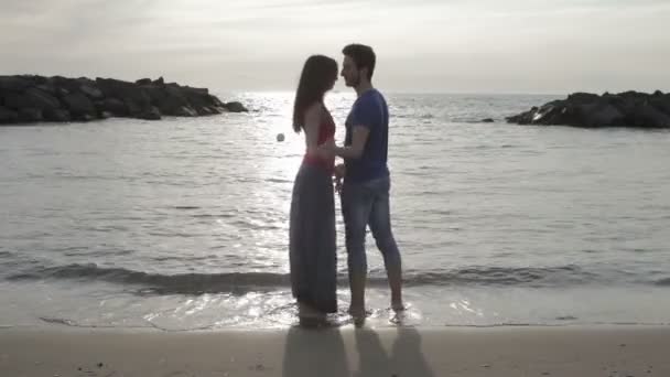 Deux amoureux dansant au son de la mer au coucher du soleil — Video