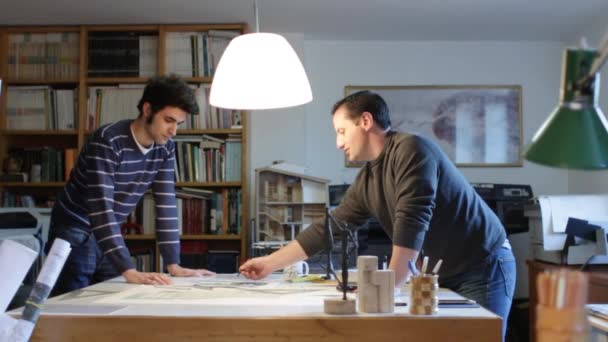 Два архітектори, вивчаючи план в офісі (Доллі) — стокове відео