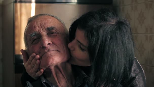 Piękna kobieta pieszczoty i pocałunki dziadka, patrząc na kamery — Wideo stockowe