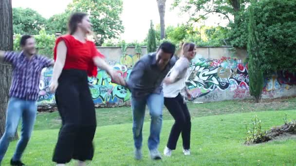 Grupo de amigos se divertindo no parque exultante - salto - abraço - corrida — Vídeo de Stock