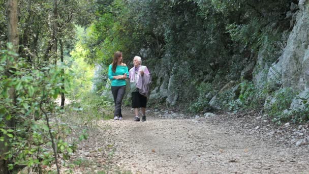 늙은 여자와 그녀의 손녀는 공원에서 산책 하는 동안 안 아 — 비디오