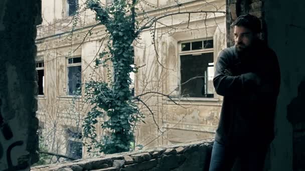 Депресивний солдат, що стоїть один і стоїть біля зруйнованого вікна — стокове відео