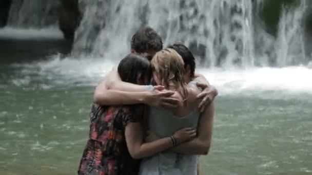 Girls and boys have fun in a river. hugging and playing with water — Stock Video
