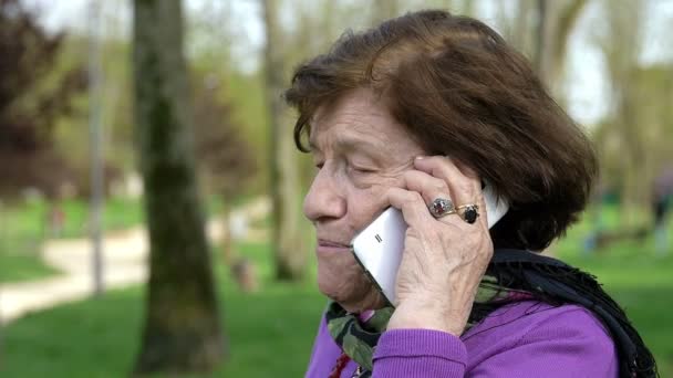Счастливая старуха по телефону разговаривает со своим сыном — стоковое видео