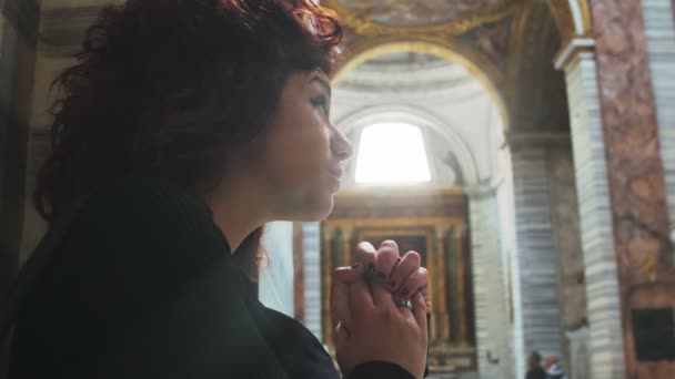 Печальная женщина молится в церкви — стоковое видео