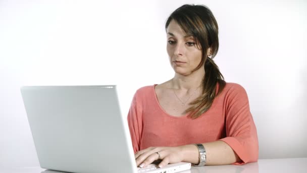 Empresária no trabalho: trabalhando com laptop branco no fundo do estúdio — Vídeo de Stock