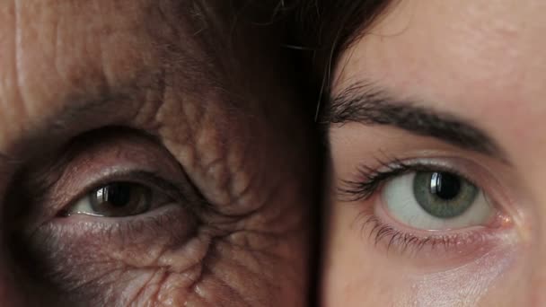 Старый и молодой глаз - бабушка и внучка смотрят в камеру вместе — стоковое видео