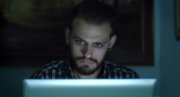 Νεαρός άνδρας που χρησιμοποιούν φορητό υπολογιστή κατά τη διάρκεια της νύχτας: κοινωνικά δίκτυα σε απευθείας σύνδεση — Αρχείο Βίντεο