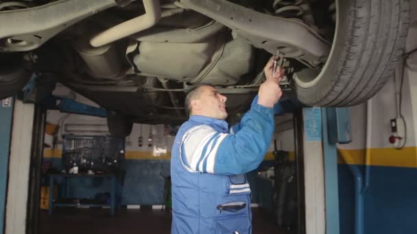 Mecánico de automóviles reparando una parte de un motor de coche — Vídeo de stock