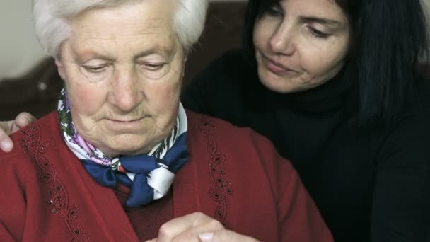 Anciana preocupada es consolada por su hija que sostiene su mano — Vídeo de stock
