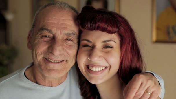 Senior man and young girl smiling together. video filmed in close-up — Stock Video