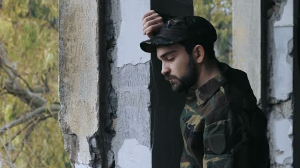 Депресивний і втрачений снайпер стоїть один і сумний в покинутій будівлі — стокове відео