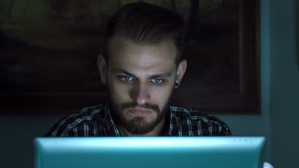 Jonge man met laptop: duisternis, internet, hebben chat en flirt met meisjes — Stockvideo