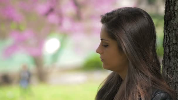 Une femme triste et bouleversée assise seule dehors — Video