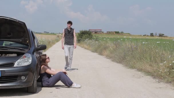 Jeune homme aide une femme qui a la voiture en panne — Video