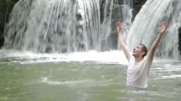 Возбужденный молодой человек в воде — стоковое видео