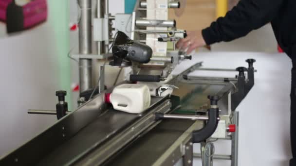 Trabajador pone botellas en la máquina para etiquetarlos — Vídeos de Stock