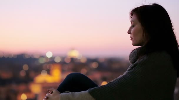 Sad and depressed woman sitting at sunset in front of a beautiful landscape — Stockvideo