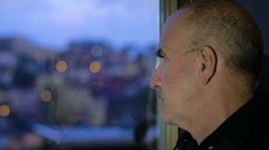 Pencereden dışarı bakan adam.