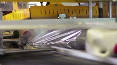 makine shrink-wrap şişe koyar.
