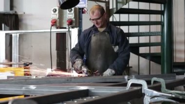 Metalde çalışan bir adam öğütücüyle çalışıyor.