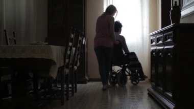 kadın bir tekerlekli sandalye Engelli kıdemli bir hugs iter.