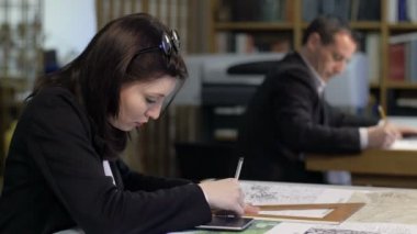 hesap makinesi ve kare cetvel ile çalışan kadın mimar: takım çalışması