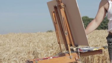 ressam bir buğday alan ortasında güzel bir manzara, Pan boyar.