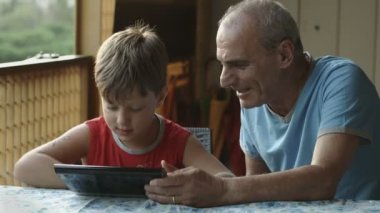Dede ve torunu tablet bilgisayar kullanarak: Aile, çocuk, yaşlı
