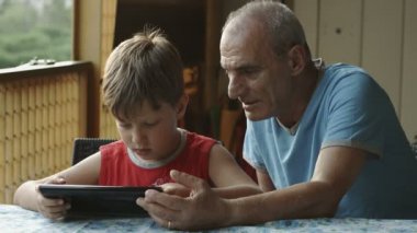 Dede ve torunu tablet bilgisayar kullanarak: Aile, çocuk, yaşlı