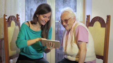 Genç kadın büyükanne işini tablet bilgisayar - üst düzey yaşam tarzı ile öğretir