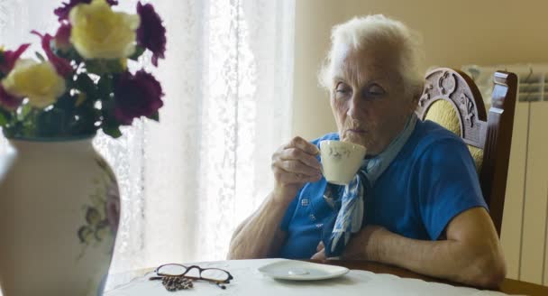 Ältere Frau trinkt eine Tasse Tee, alt — Stockvideo