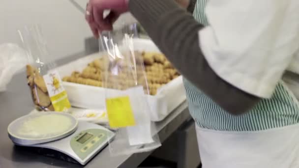 Chef de pastelaria coloca biscoitos nos pacotes — Vídeo de Stock